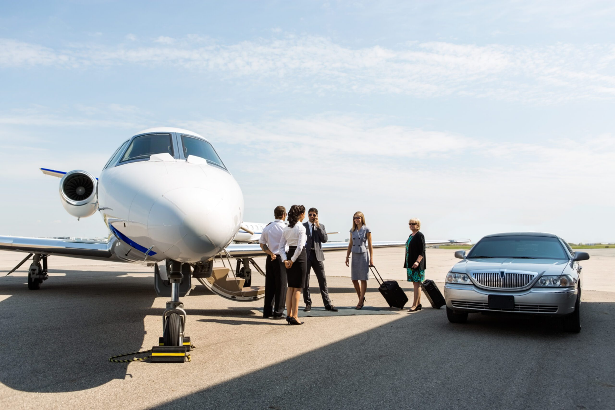 Travellers getting ready to board a private jet on the apron