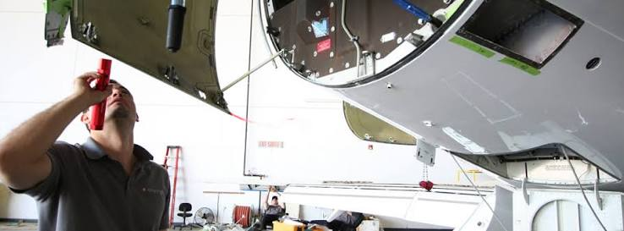 Aviation mechanic inspecting the engine of a private jet during routine maintenance